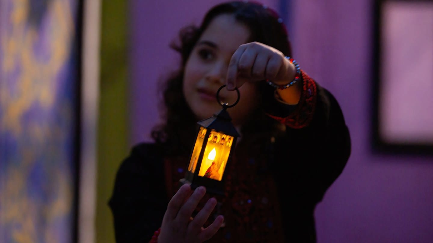 Ein Mädchen hält eine traditionelle palästinensische Lampe, die für den Ramadan typisch ist