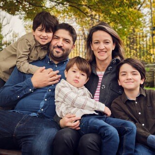 Happy family sitting together on bench at park