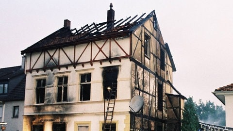 Brandanschlag - Feuerwehrmänner vor dem abgebrannten Haus der türkischen Familie Genc in Solingen