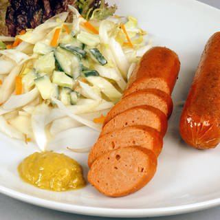 Vegetarische Wurst auf Teller mit Senf und Salat