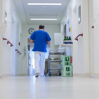 Ein Krankenpfleger geht über einen Flur im Krankenhaus