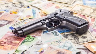 Handgun on the various banknotes background.