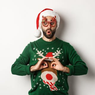 Ein Mann in einem hässlichen Weihnachtspullover