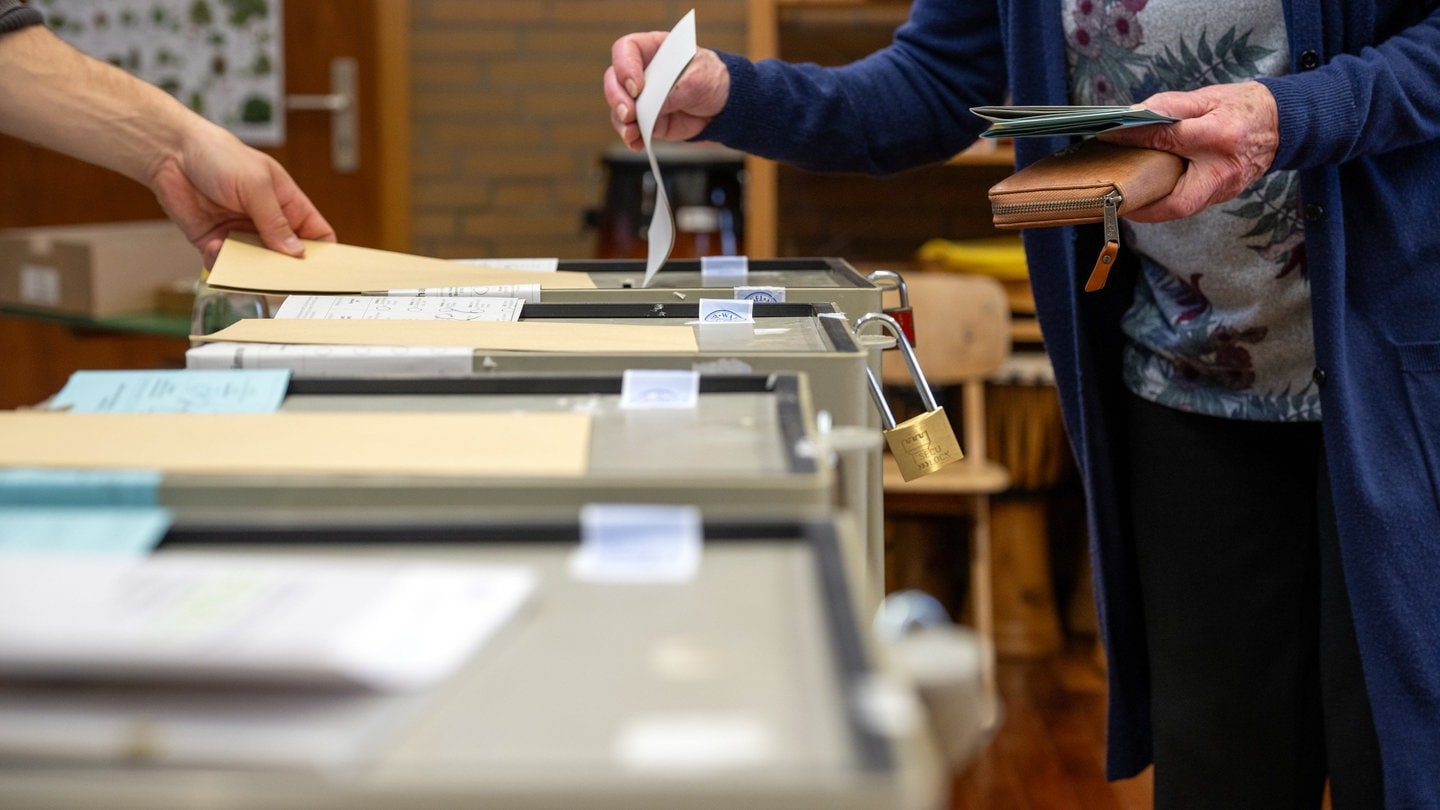 Ein Frau wirft ihren Stimmzettel in die Wahlurne.