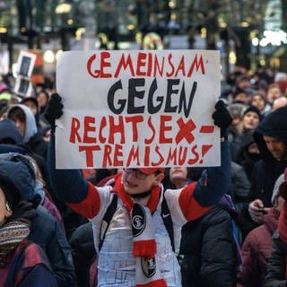 Ein Teilnehmer der Demonstration "Hamburg steht auf" gegen die AFD und Rechtsextremisms hält ein Plakat mit der Aufschrift "Gemeinsam gegen Rechtsextremismus".