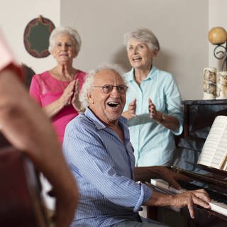 Seniorinnen und Senioren musizieren in einem Altenheim.