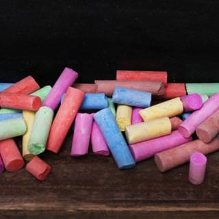 Multicolored school chalk on blackboard background