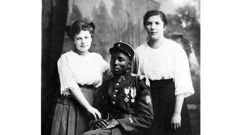 Ein Portrait eines schwarzen Mannes mit zwei weißen Frauen während der Rheinlandbesetzung