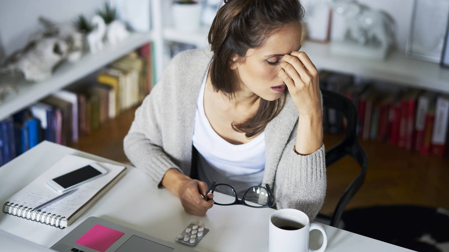 Young woman at home at desk suffering headache model released Symbolfoto