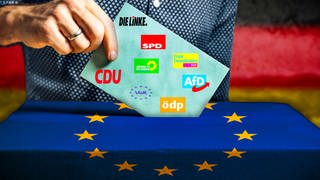 Themenbild Europawahl 2024 in Deutschland: Mann wirft einen Stimmzettel in eine Wahlurne mit Flagge der Europäischen Union.