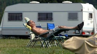 Campingidylle - Mann schläft auf einem Liegestuhl auf dem Campingplatz Kleinröhrsdorf