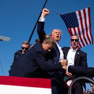 Republican presidential candidate former President Donald Trump is surrounded by U.S. Secret Service agents at a campaign rally, Saturday, July 13, 2024, in Butler, Pa. (AP PhotoEvan Vucci)