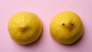 Zwei Zitronenhälfte, eine mit einem Piercings als Symboldbild für Brustwarzen