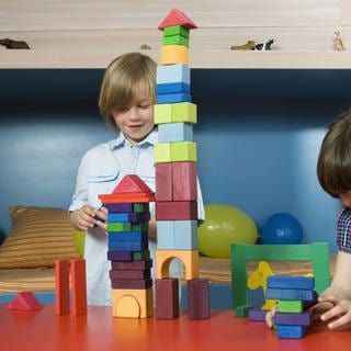 Boy (8-9) and girl (6-7) playing building bricks, portrait model released