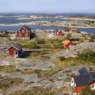 Rote Holzhäuser an der felsigen Küste, Stockholmer Schärengarten, Schäreninsel Huvudskär, Schweden, Europa 