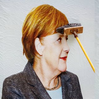 Angela Merkel ist auf einem Wahlplakat zu sehen, welches frisch geklebt wurde. Kleister.