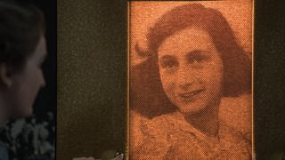 Eine Besucherin beleuchtet durch Knopfdruck das Porträt der Anne Frank am 24.03.2017 in Frankfurt am Main (Hessen)