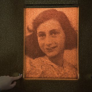 Eine Besucherin beleuchtet durch Knopfdruck das Porträt der Anne Frank am 24.03.2017 in Frankfurt am Main (Hessen)