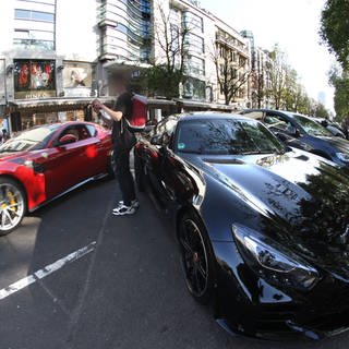 Die Königsallee in der Innenstadt von Düsseldorf ist bekannt für Auto-Poser, die auf der Luxusflaniermeile ihre teuren Autos oftmals recht lautstark zur Schau stellen.