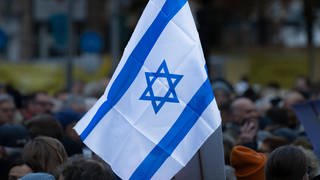 Eine Israel-Fahne weht im Wind. Unter dem Motto Nie wieder ist jetzt demonstrierten am 17.11.2023 rund 1.500 Menschen auf dem Opernplatz in Frankfurt am Main gegen Judenhass