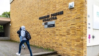 Ferdinand-Porsche-Gymnasium Stuttgart-Zuffenhausen. Schüler am Eingang vor Namensschild der Schule. Unter dem Namen prangt ein Schild mit der Aufschrift: Schule ohne Rassismus. Schule mit Courage. 