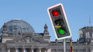 Ampel-Aus: Ampel mit defektem gelben Licht in Fotomontage vor dem Bundestag