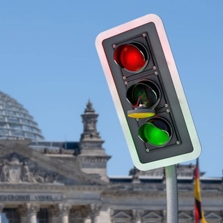 Ampel-Aus: Ampel mit defektem gelben Licht in Fotomontage vor dem Bundestag