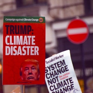 A protester holds a placard describing the election of Donald Trump as a 'climate disaster' during the demonstration. 