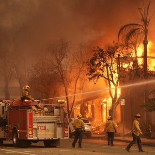 Feuerwehrleute löschen ein brennendes Gebäude in der Lake Avenue in der Innenstadt von Altadena.