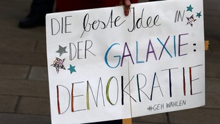 Plakat mit Schriftzug: Die beste Idee in der Galaxie - Demokratie