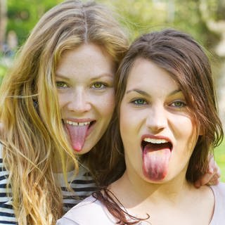 Zwei Teenager strecken ihre Zungen heraus