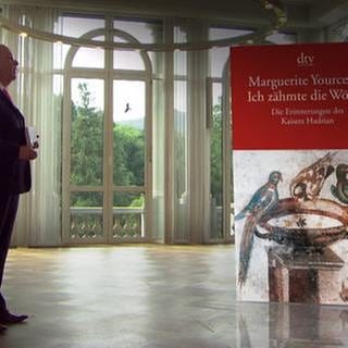 Denis Scheck und daneben das Buch "Ich zähmte die Wölfin" von Marguerite Yourcenar