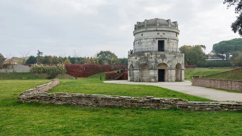 Grabmahl Theoderichs des Großen in Ravenna: Zweistöckiger, spätantiker Rundbau aus Kalkstein in einer ausgedehnten Grünanlage.