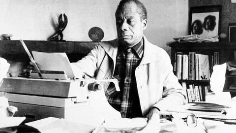 James Baldwin sitzt an Schreibmaschine