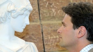 Jonas Grethlein, Professor für griechische Literatur, schaut eine Gipsstatue der Göttin Athene in der Universität in Heidelberg an.