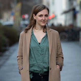 Die Autorin und freie Journalistin Valerie Schönian steht in Berlin an einer Straße.