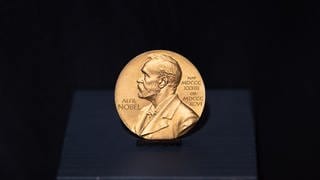 Medaille des Literatur-Nobelpreises, der 1999 an Günter Grass verliehen wurde, auf schwarzem Grund.