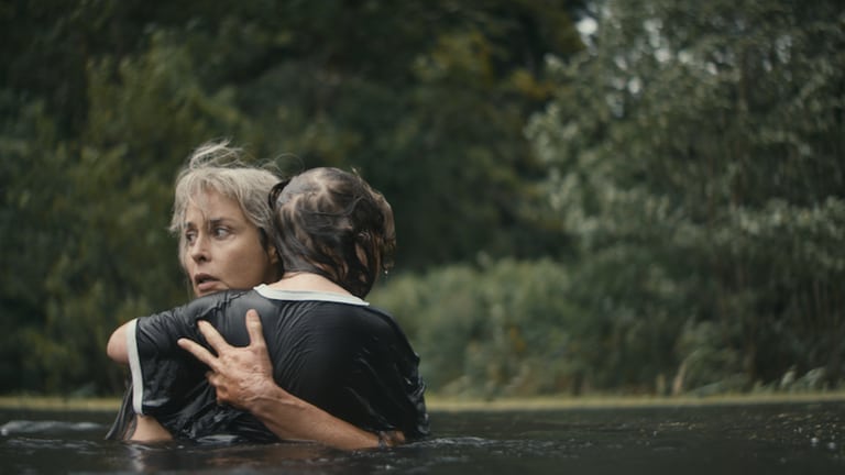 Szene aus dem Film „Milchzähne“: Frau umarmt Kind im Wasser