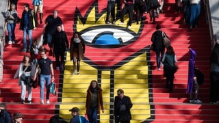 Zahlreiche Besucher gehen die Treppe mit dem Logo der Leipziger Buchmesse hinab. 