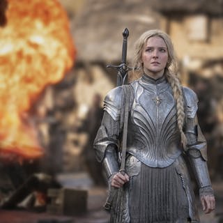 Die Schauspielerin Morfydd Clark steht als Galadriel in der Serie "Die Ringe der Macht" vor einem Feuer