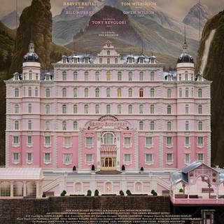 Ein altes, aber luxuriöses Hotel mit pinker Fassade und der Aufschrift "The Grand Budapest Hotel"