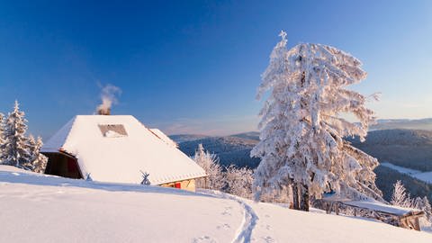 Verschneite Hütte auf dem Belchen mit Blick zum Feldberg, Schwarzwald, Baden-Württemberg