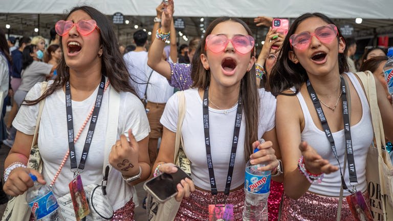 Drei junge Frauen mit pinken Sonnenbrillen und voller Euphorie