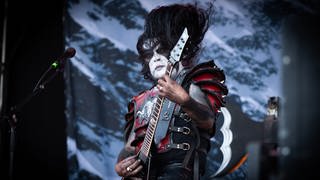 Abbath Doom Occulta, Sänger und Gitarrist der Black Metal Band Abbath auf der Bühne mit schwarz-weiß geschminktem Gesicht 
