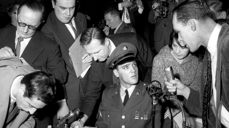 Elvis Presley umringt von Reportern