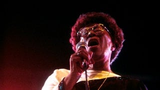 Ella Fitzgerald singt ins Mikrofon bei einem Auftritt 1983