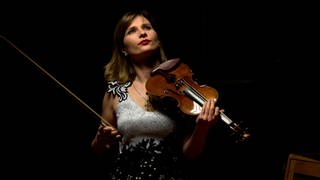 Lisa Batiashvili mit der Geige in der Hand vor einem schwarzen Hintergrund.