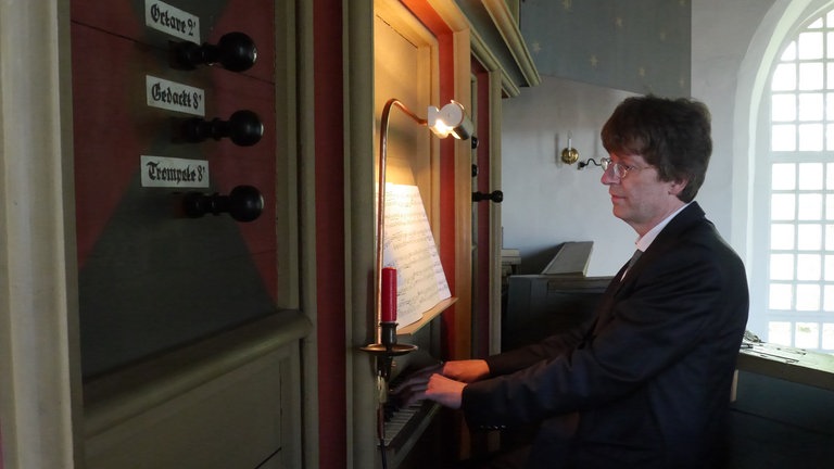 Organist sitzt an der Rysumer Orgel.