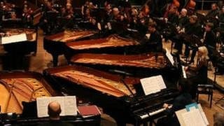 Musiker des SWR Sinfonieorchesters Baden-Baden und Freiburg sowie Solisten an sechs Flügeln bei einem Konzert