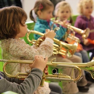 Kinder spielen Trompete